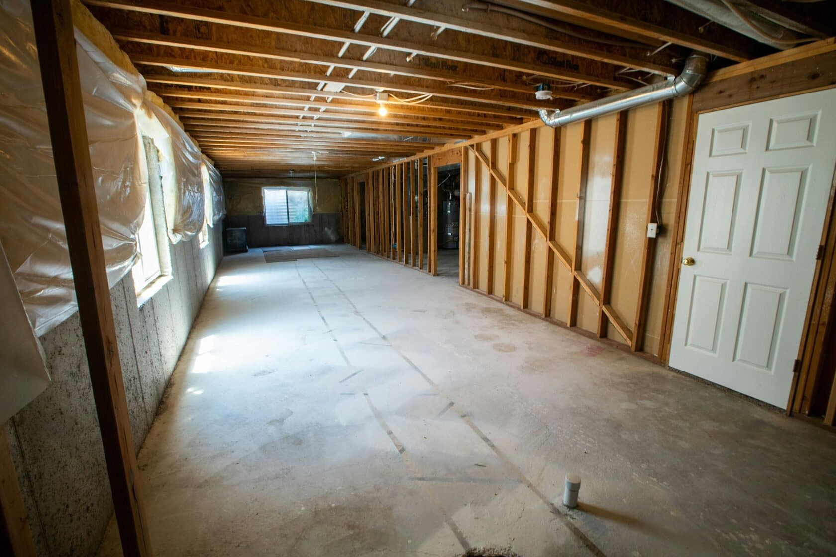 A basement with damaged drywall removed down to the studs