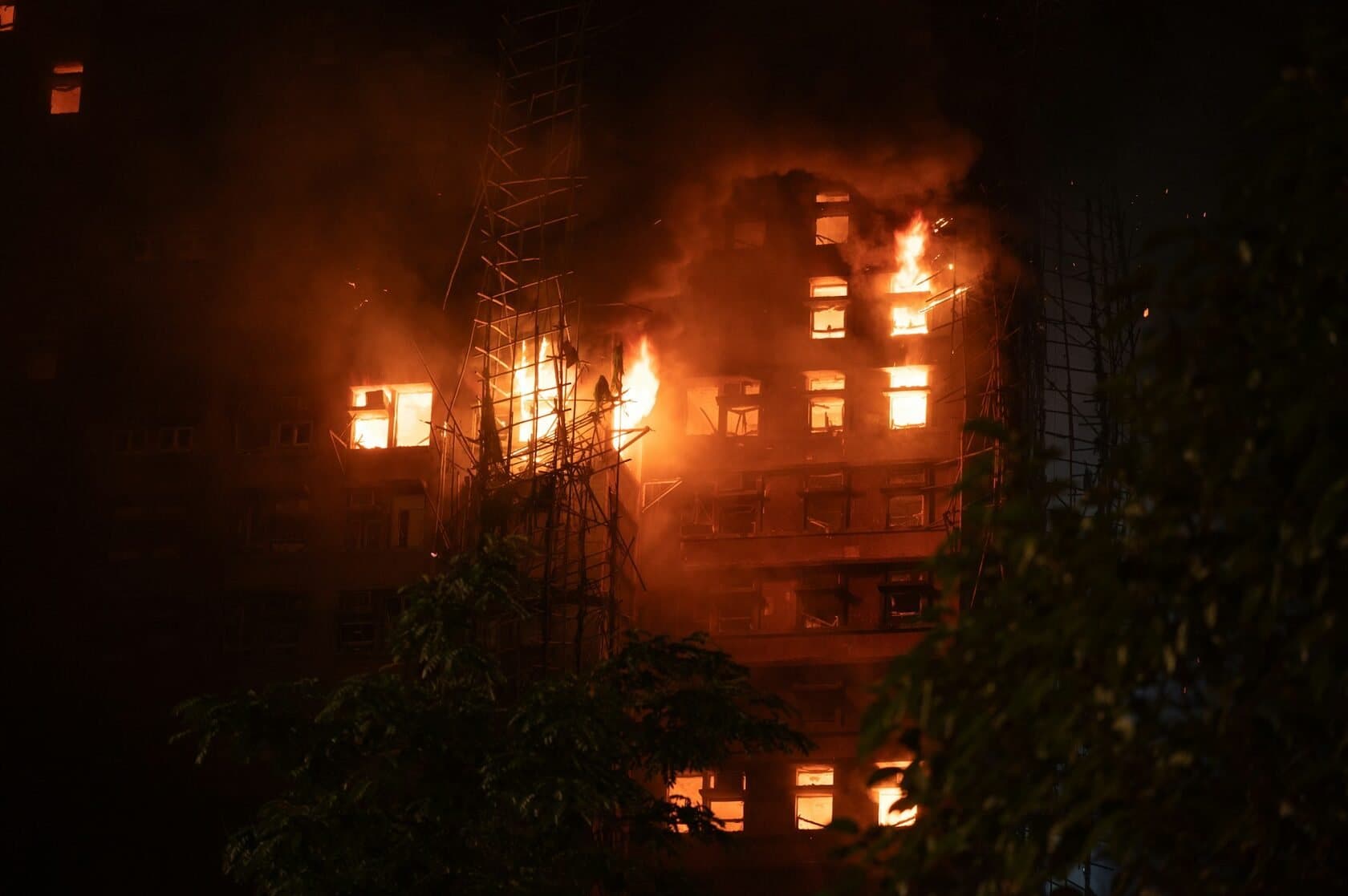 Fire burning through the upper floors of an apartment building at night