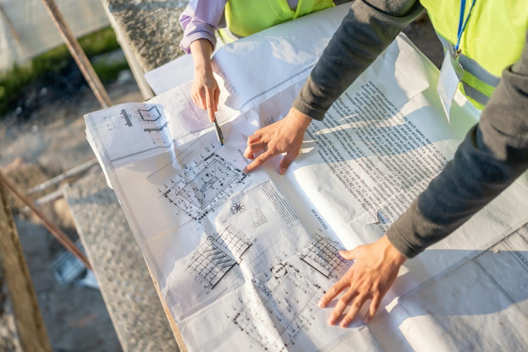 Builders marking up construction drawings on site