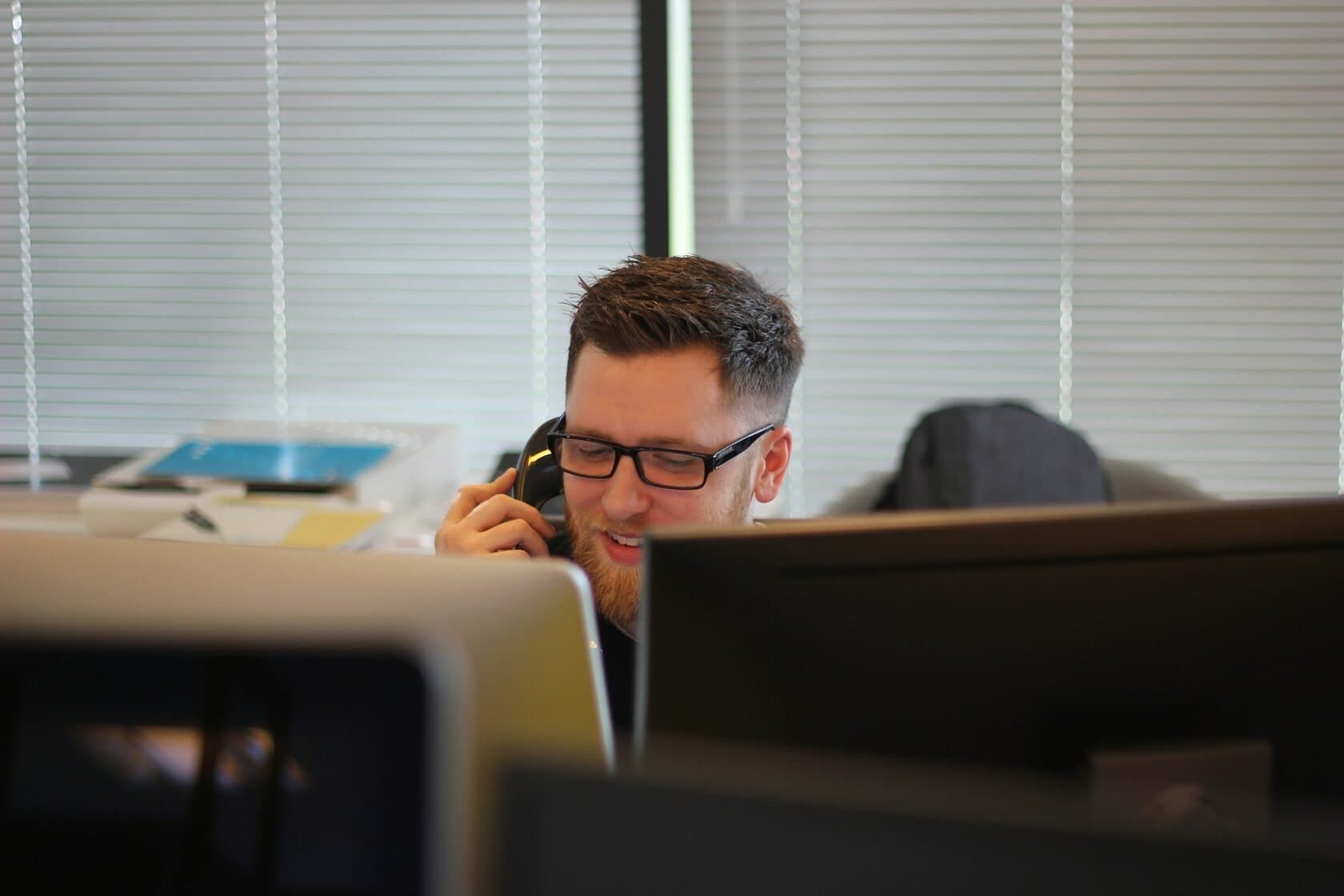 Dispatcher on the phone at a desk with two monitors