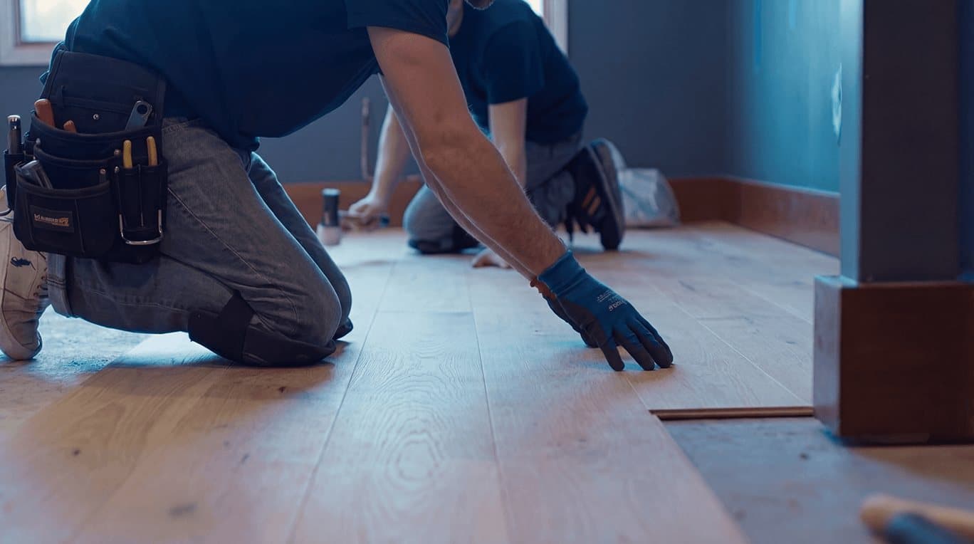 Technician installing new flooring during repairs