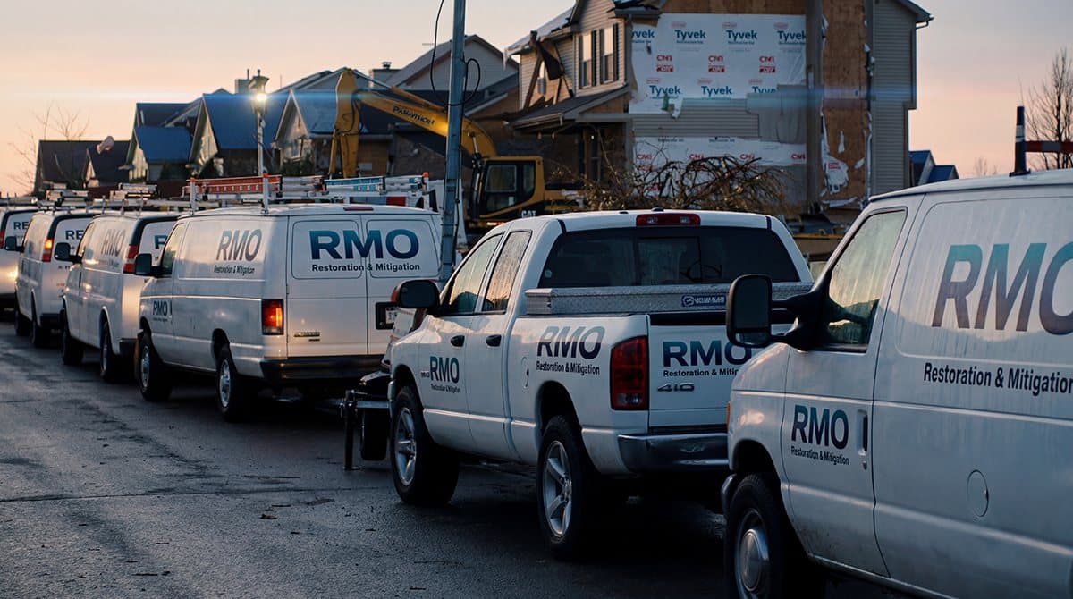 A row of RMO pickup trucks and vans parked on a residential street